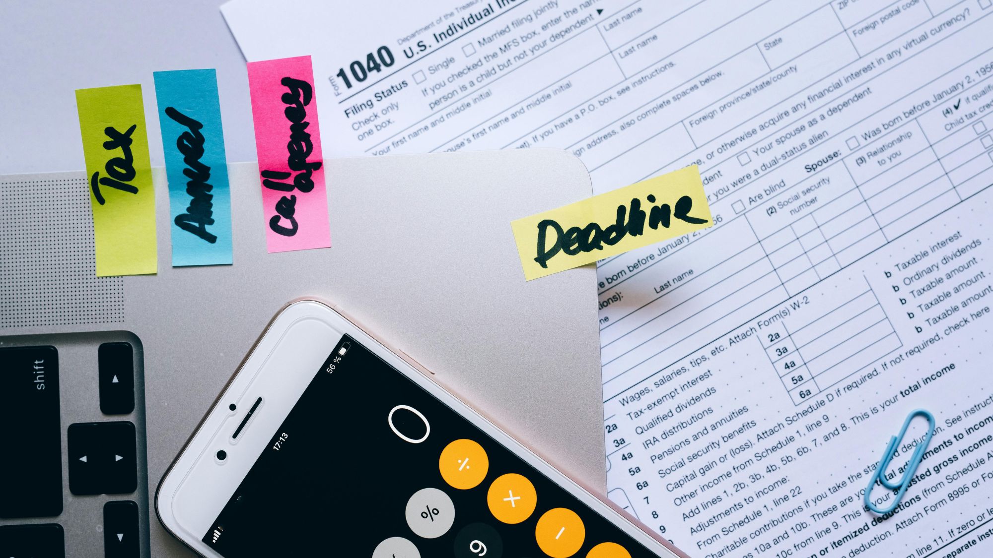A calculator with documents highlighting a payroll compliance checklist