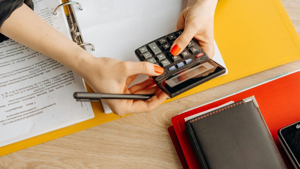 A woman using a calculator for e-commerce bookkeeping and reconciliation errors