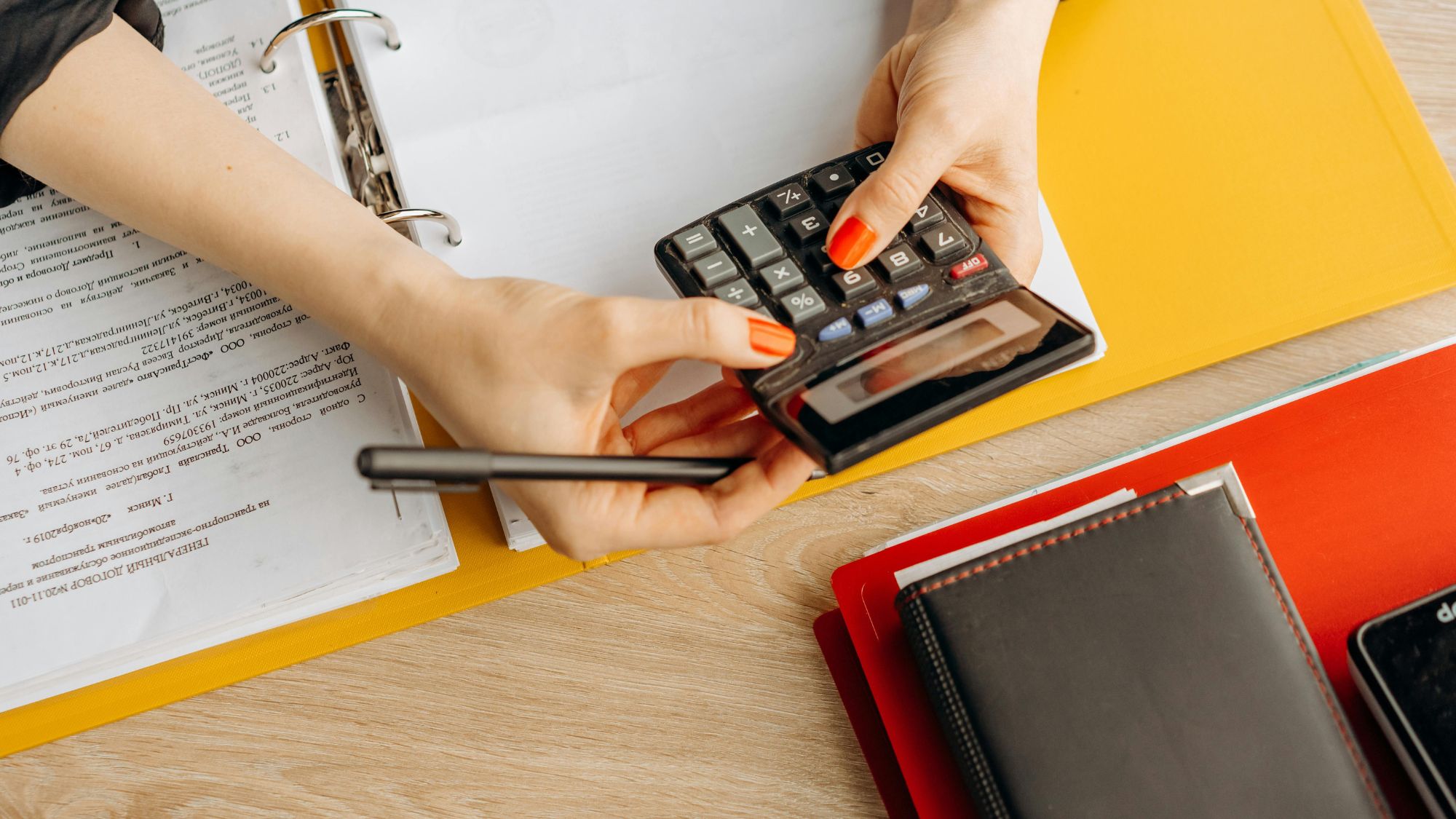 A woman using a calculator for e-commerce bookkeeping and reconciliation errors